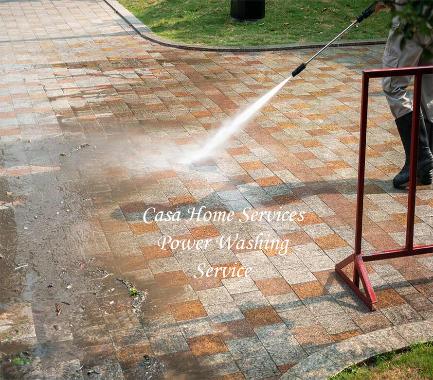 A person power washing a side walk.